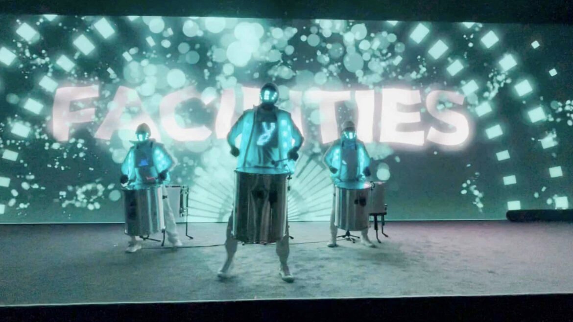 Dance crew performance with futuristic LED costumes and vibrant background. Dynamic dance performance by Mixd Elements Dance Crew with LED costumes and digital backdrop.